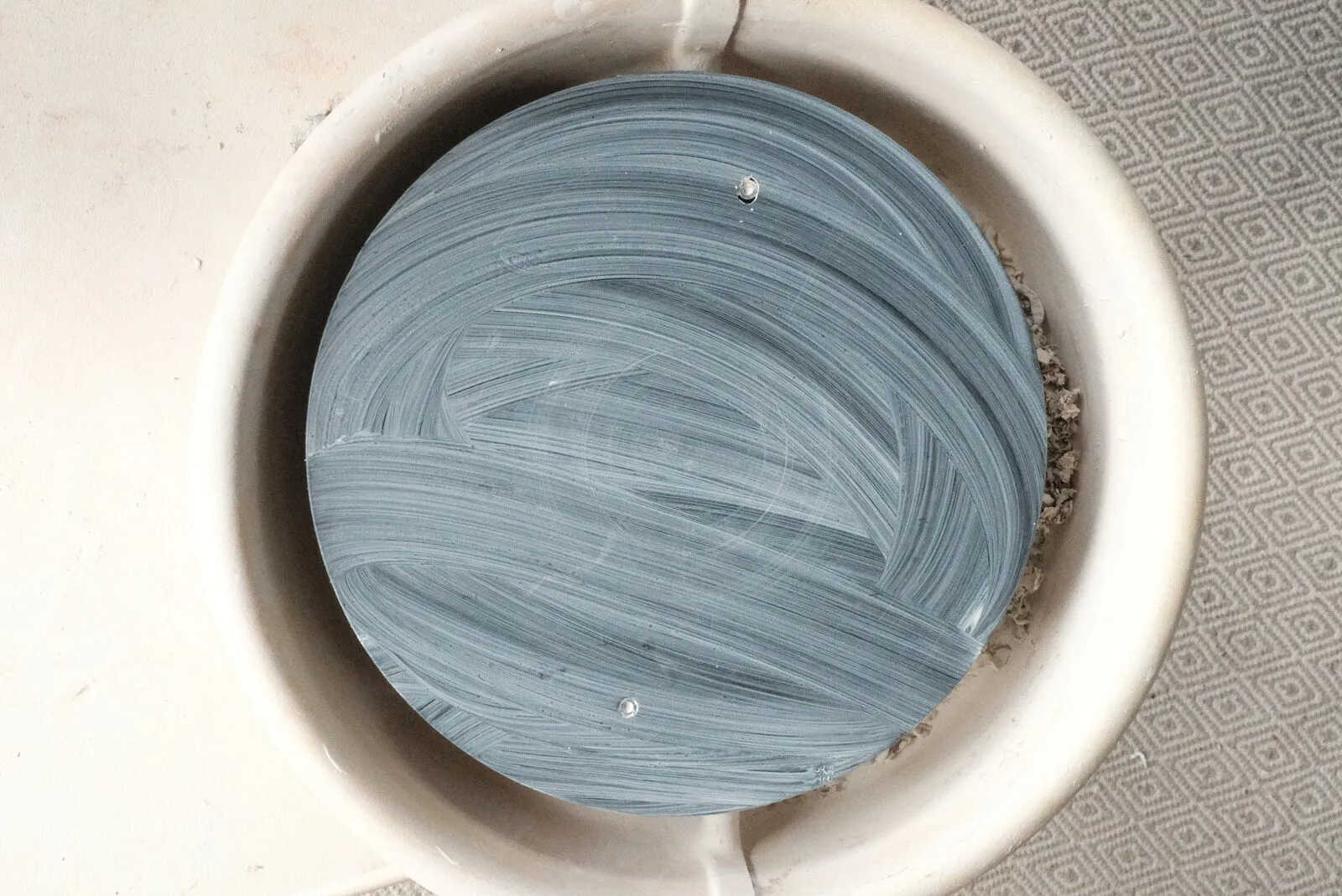 Overhead view of Kelly's pottery wheel, the bat swirled with blue-grey slip